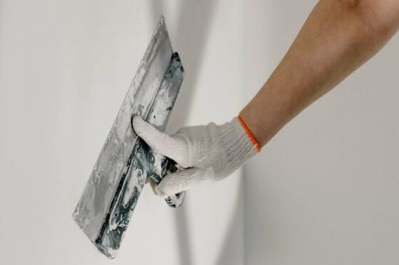 Personne qui applique une couche de plâtre sur un mur