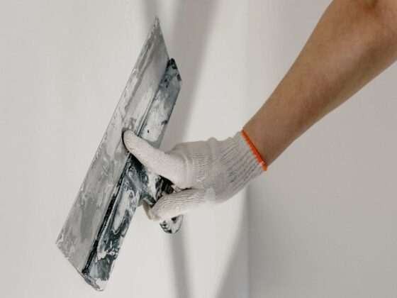 Personne qui applique une couche de plâtre sur un mur