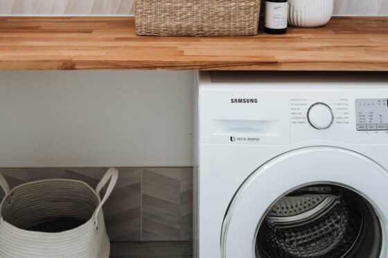 Image d'une machine à laver à côté d'un panier à linge
