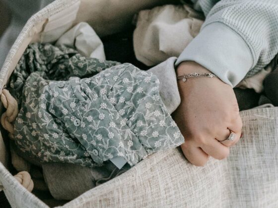 Femme qui tient un panier remplit de linge propre sous son bras