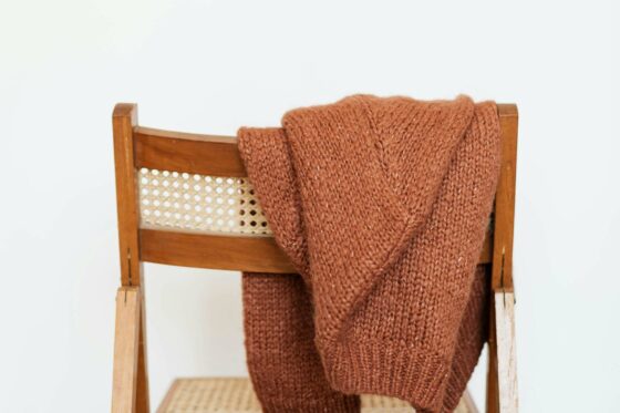 Pull marron posé sur une chaise