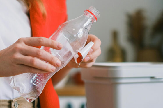 Femme essayant de retirer une étiquette d'une bouteille en plastique