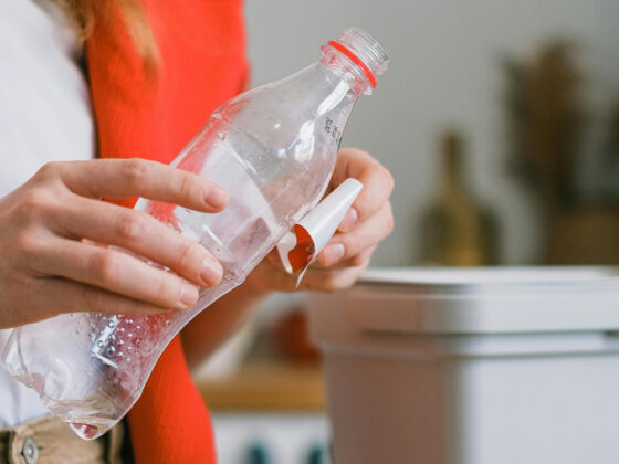 Femme essayant de retirer une étiquette d'une bouteille en plastique