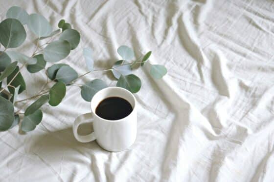 Image d'une tasse de café posée sur un tissu blanc
