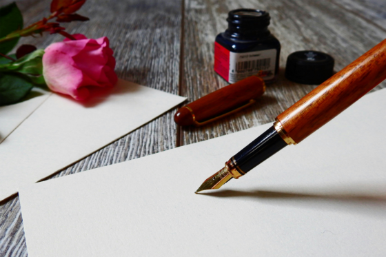 Pot d'encre posé sur un bureau avec un stylo plume
