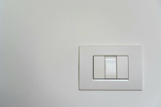 Image de 3 interrupteurs muraux blancs en PVC.