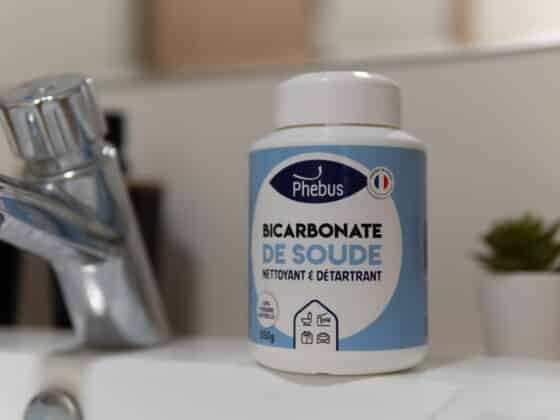 Image d'un pot de bicarbonate de soude Phebus posé sur le rebord d'un lavabo de salle debain