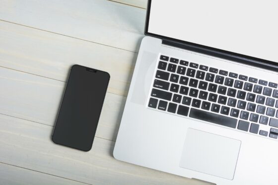 Image d'un téléphone et d'un ordinateur portable posés sur une table