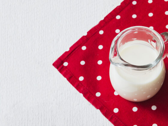 Image d'un récipient contenant du lait maternel, posé sur un tissu rouge.