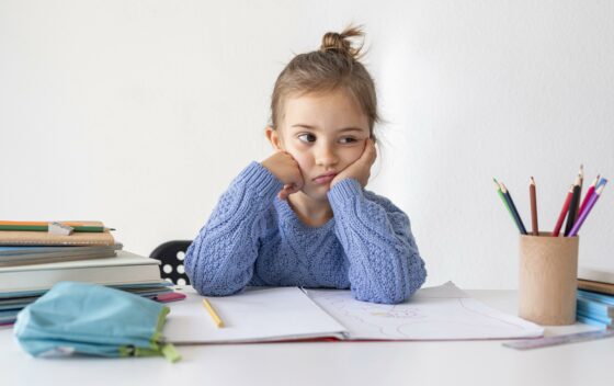 Image d'une petite fille assise à son bureau pour faire ses devoirs